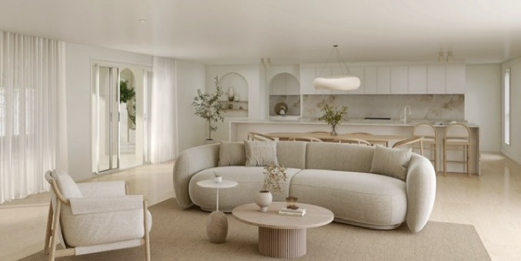 Light, neutral living room with curved sofa, timber accents and open-plan kitchen